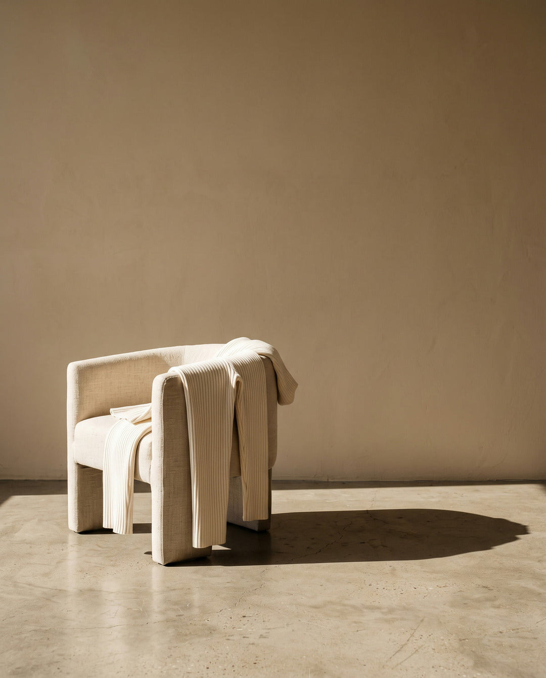 Soft ivory loungewear set draped over a low linen chair
